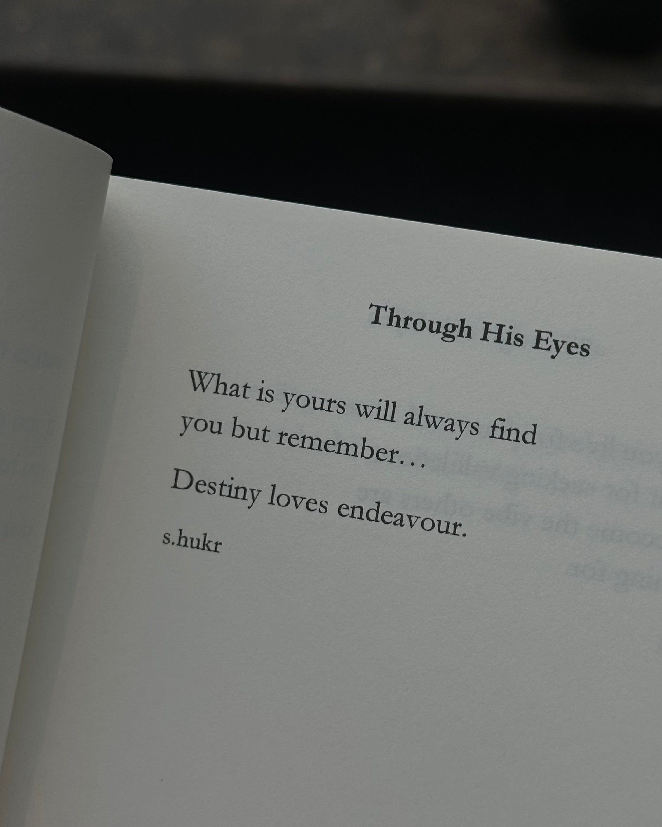 An open book showing a printed quote page titled 'Through His Eyes' with text from Shukr