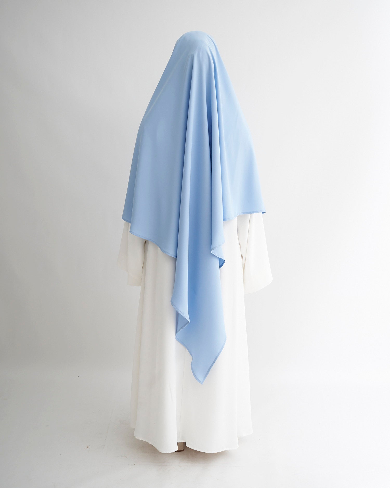 Light blue scarf draped over a white garment on a plain background