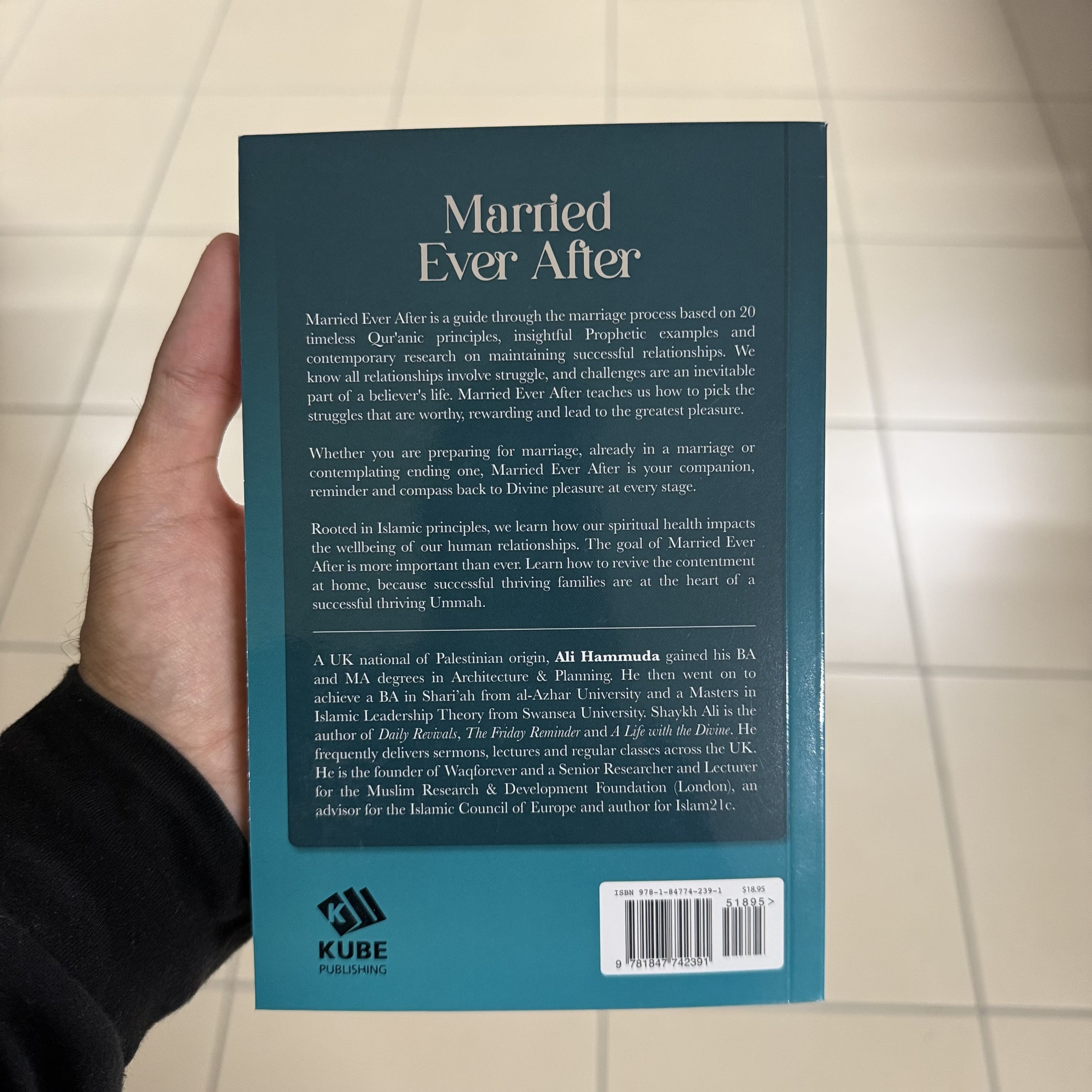 Book titled 'Married Ever After' held by a hand with a neutral background