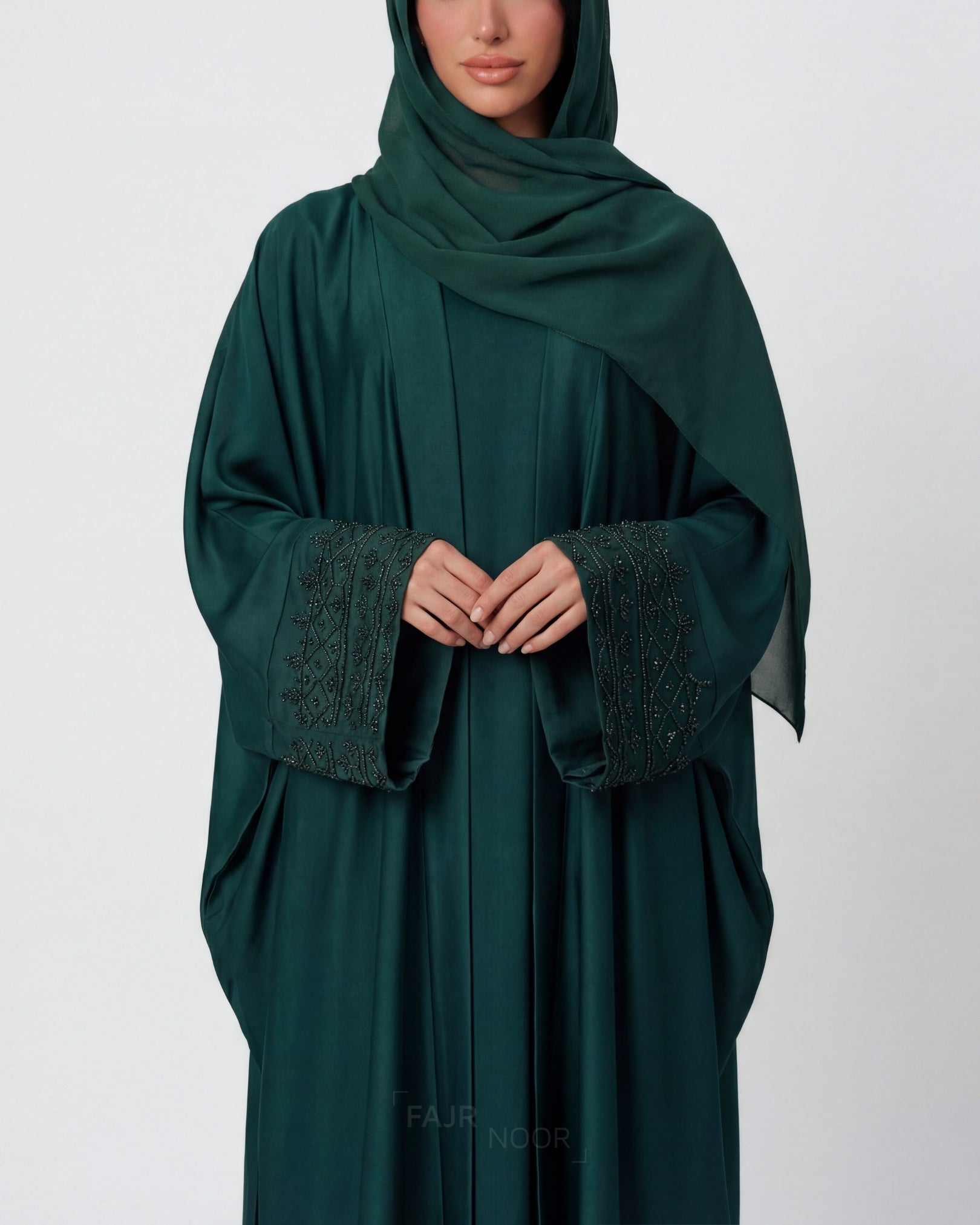 Green abaya with textured cuffs on a white background