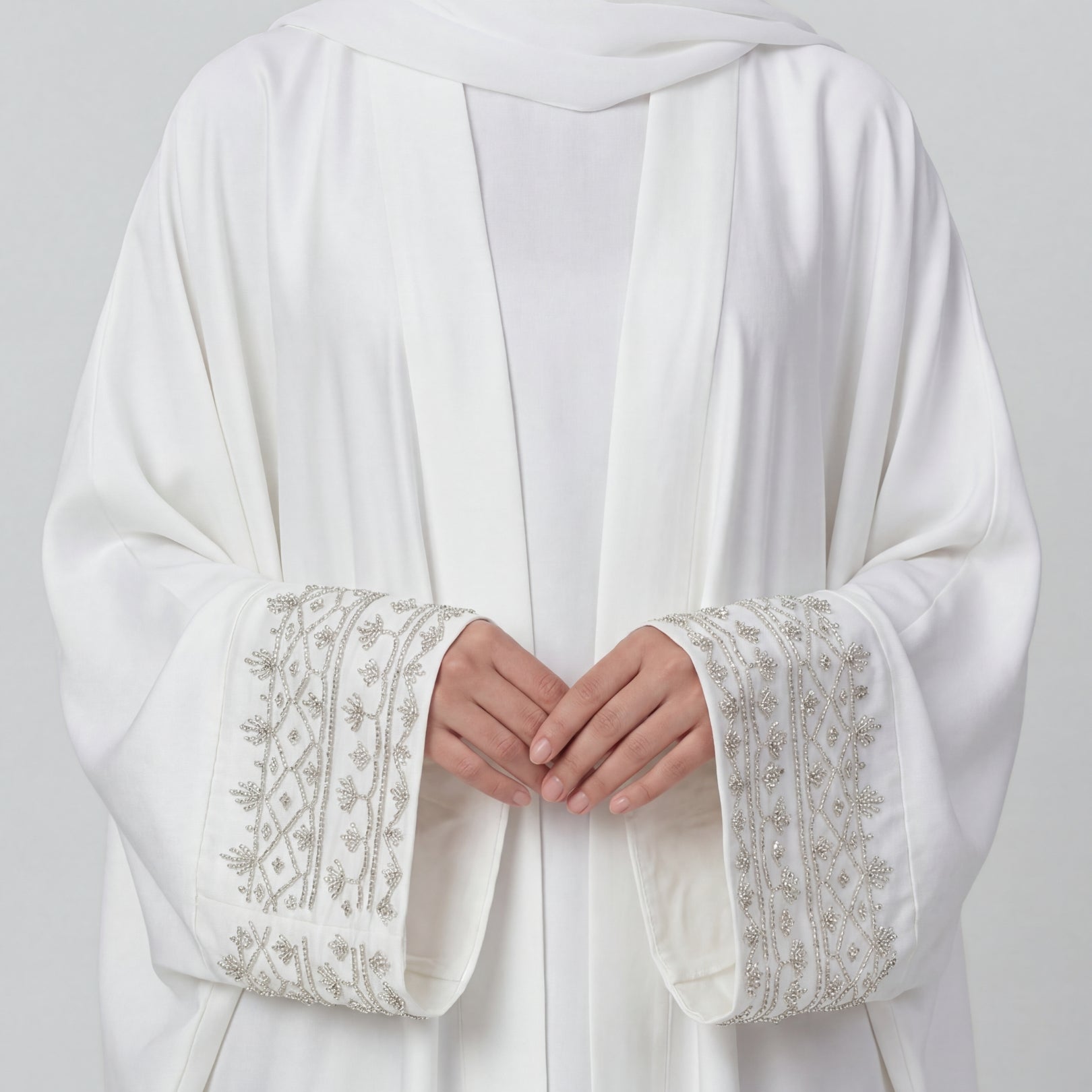 White garment with embroidered cuffs on a plain background