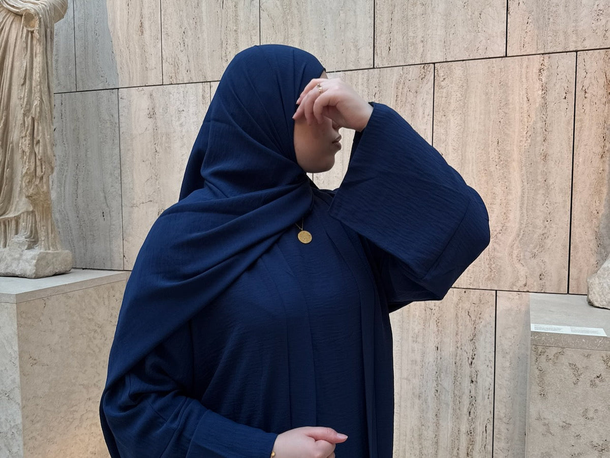women wearing navy abaya with ayatul kursi necklace