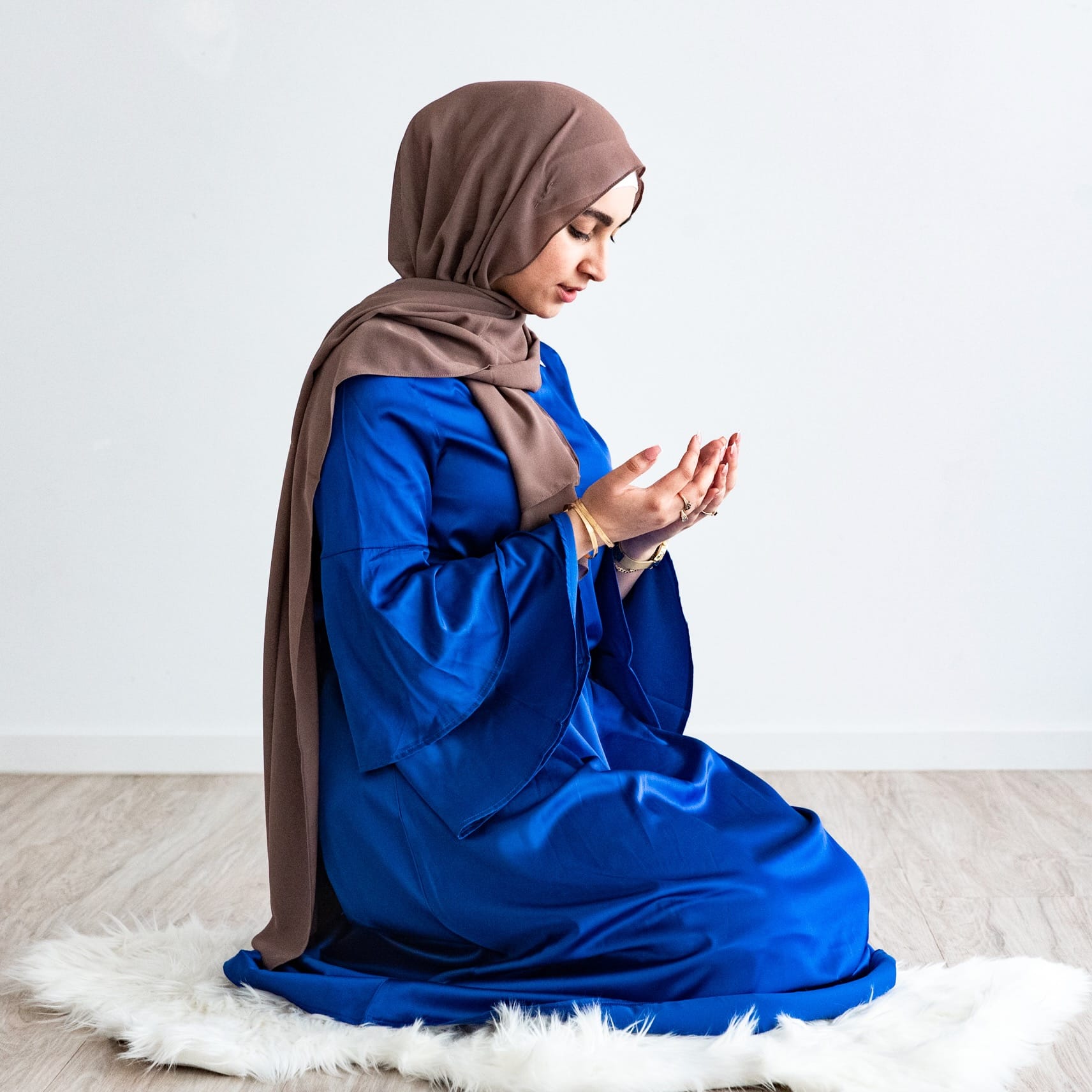 Muslim women in hijab making dua prayer in satin blue dress abaya with nude hijab melbourne brisbane sydney australia online hijab shop muslim clothing shopping
