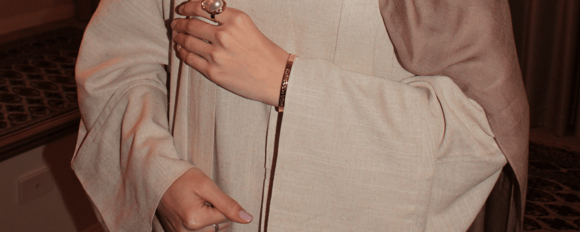 Close-up of a person wearing a light-colored garment with a blurred background