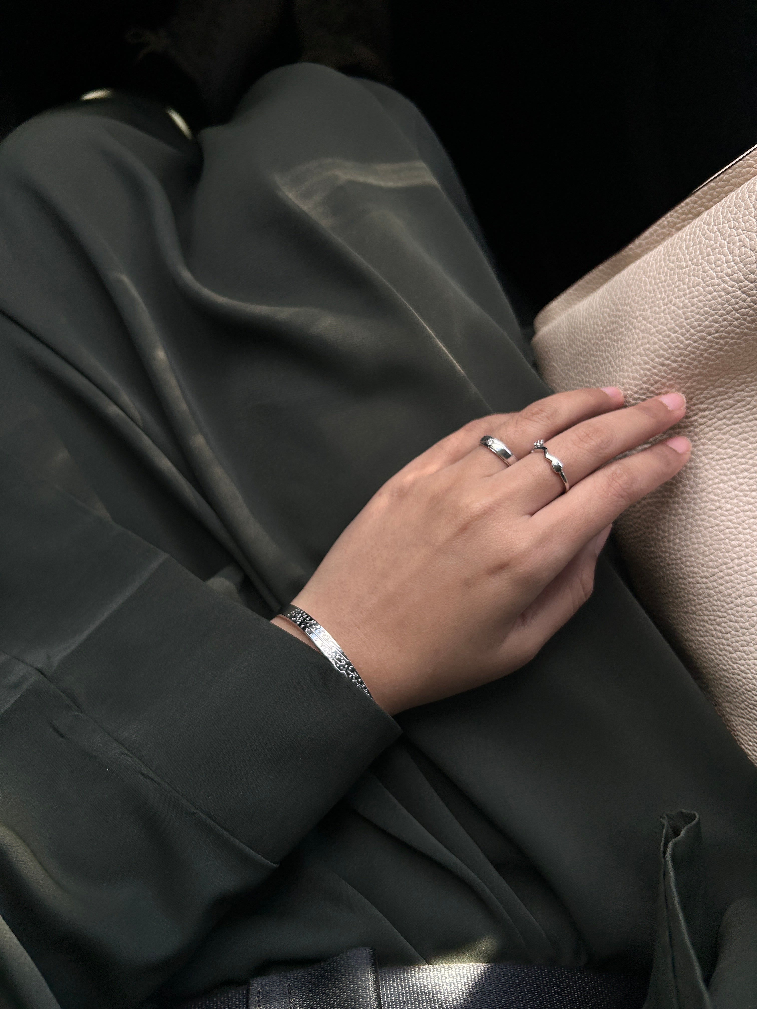Close-up of a hand with rings on a textured surface