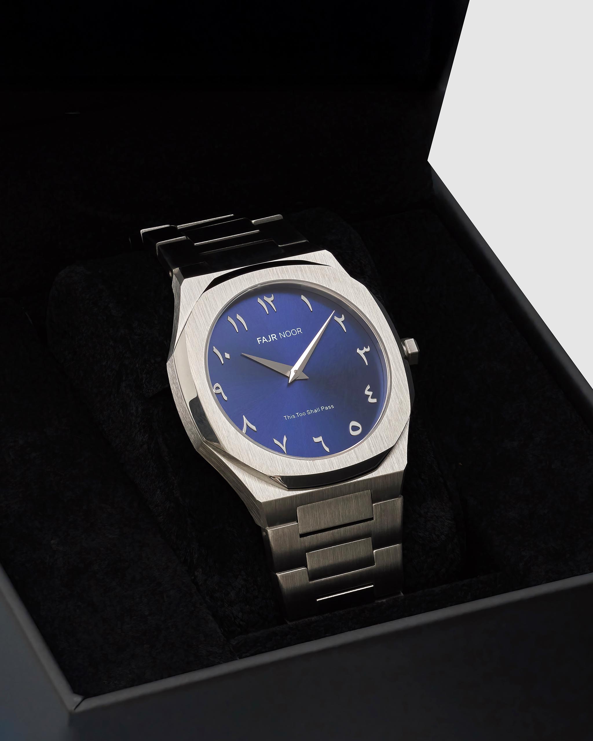 Watch with blue face and silver metal strap in a black box