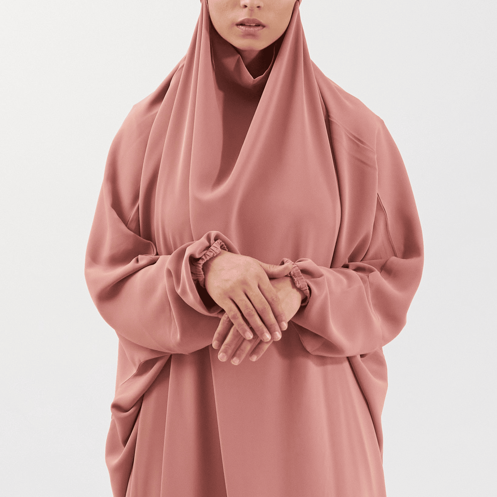 Person wearing a pink hijab and dress on a light gray background