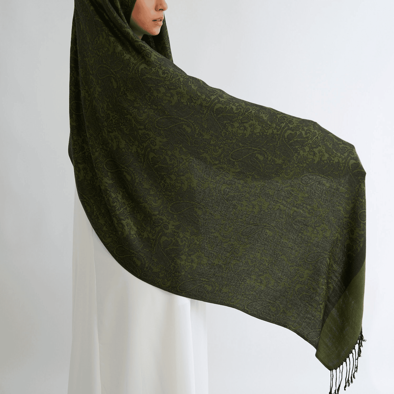 Person wearing a green patterned scarf on a white background