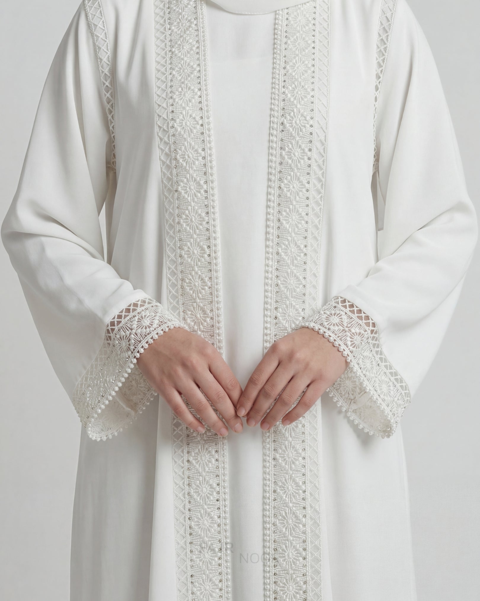 White garment with intricate lace detailing on a plain background