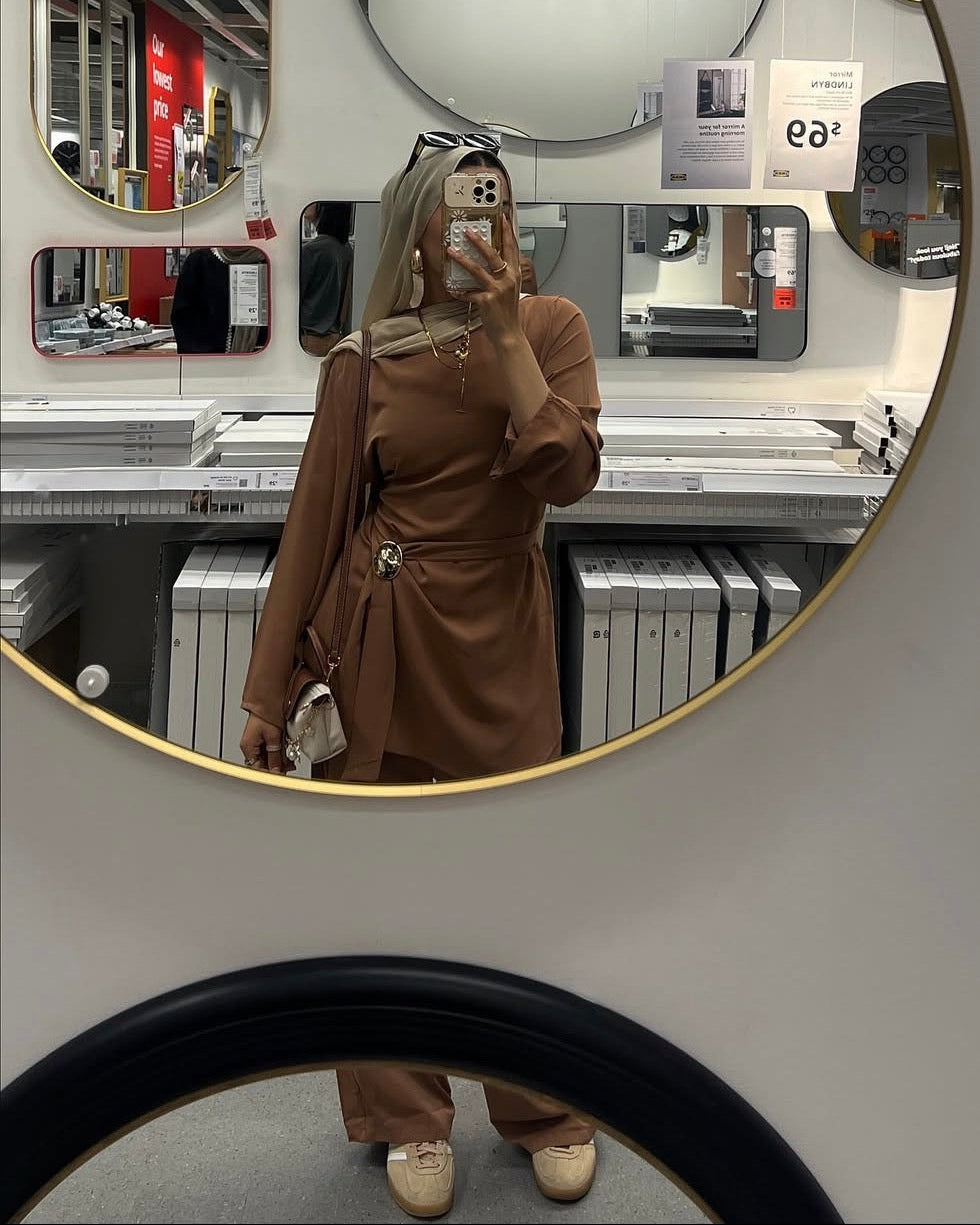 Person taking a mirror selfie in a store setting