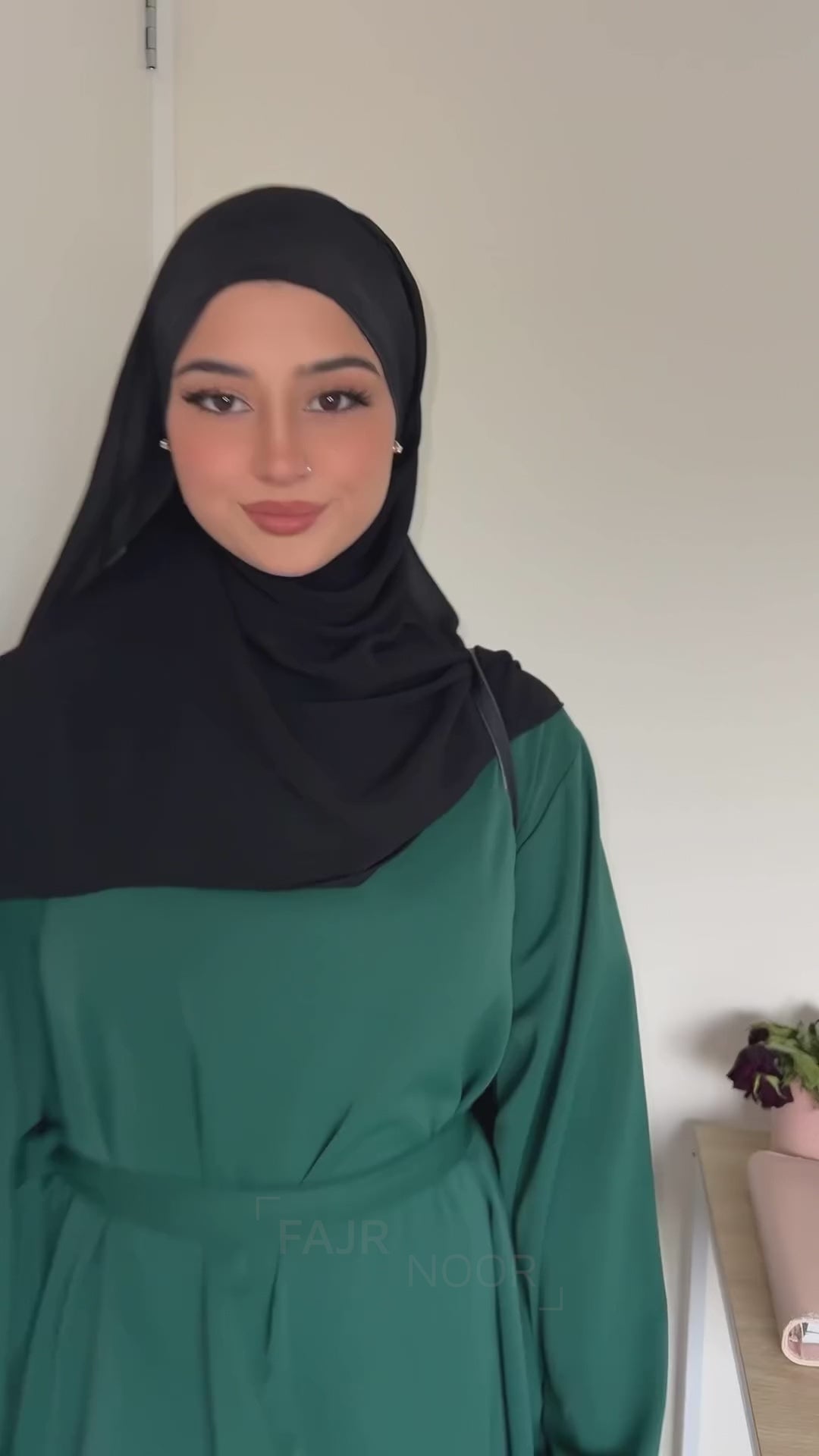 Woman wearing the Fajr Noor Khatijah Abaya in emerald with a black hijab