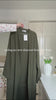 Khaki green Fajr Noor crinkle abaya on a hanger, styled with a Palestine keffiyeh pendant necklace