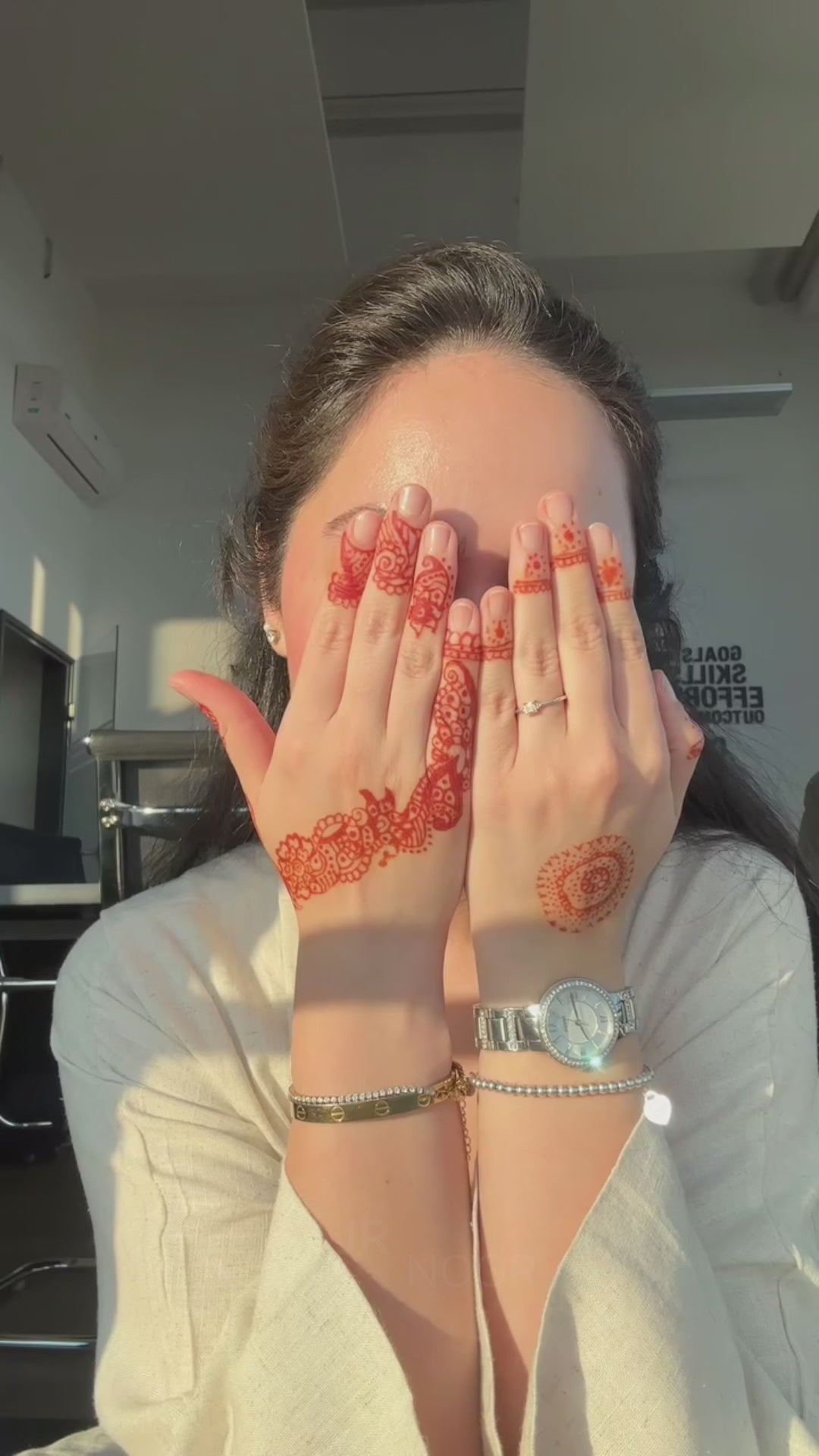 Woman wearing the Fajr Noor Aya Linen Abaya in sand, showing intricate henna designs on her hands