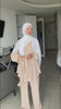 Woman wearing the Fajr Noor Sarah Set in cream, a flowy modest co-ord top and pants, styled with a white pashmina hijab draped elegantly.