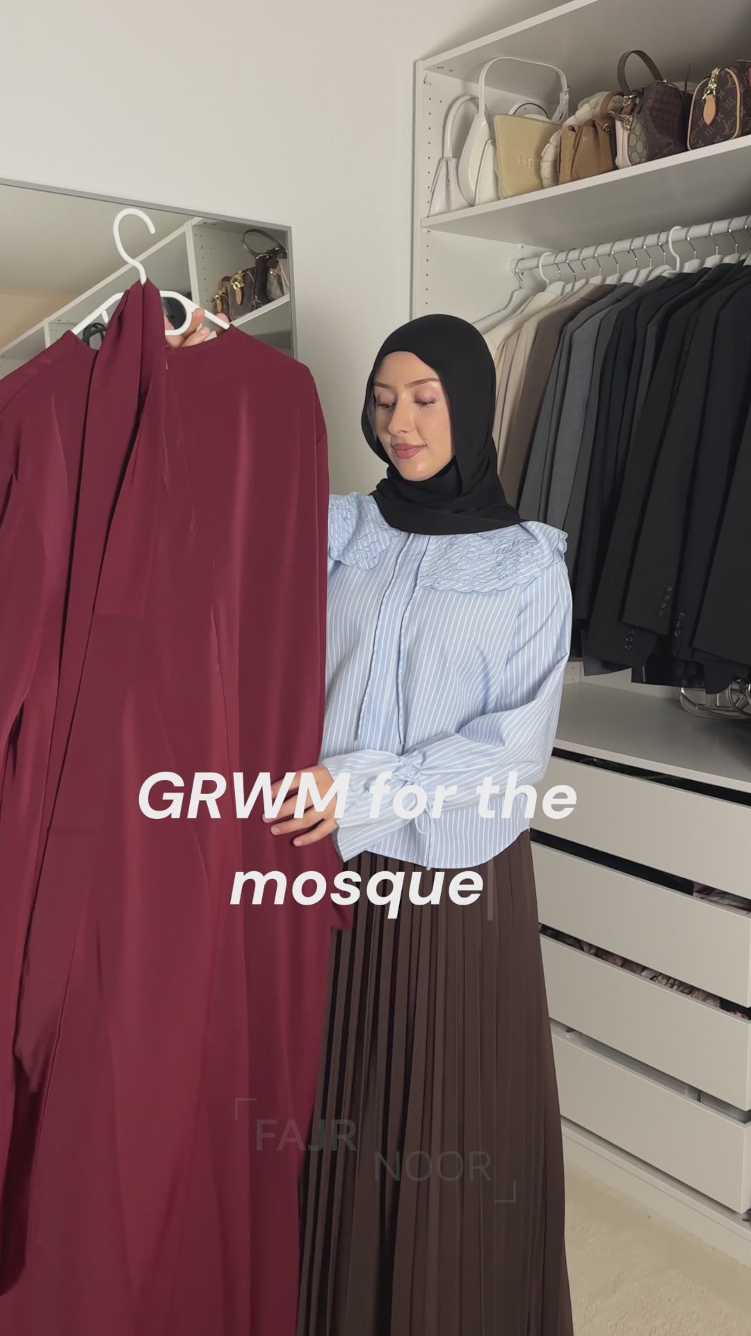Woman getting ready for the mosque, holding up the Fajr Noor Khatijah Abaya in maroon with a berry chiffon khimar