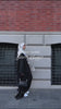 Woman wearing the Fajr Noor Aya Linen Abaya in black with a white hijab, walking outdoors as a summer essential