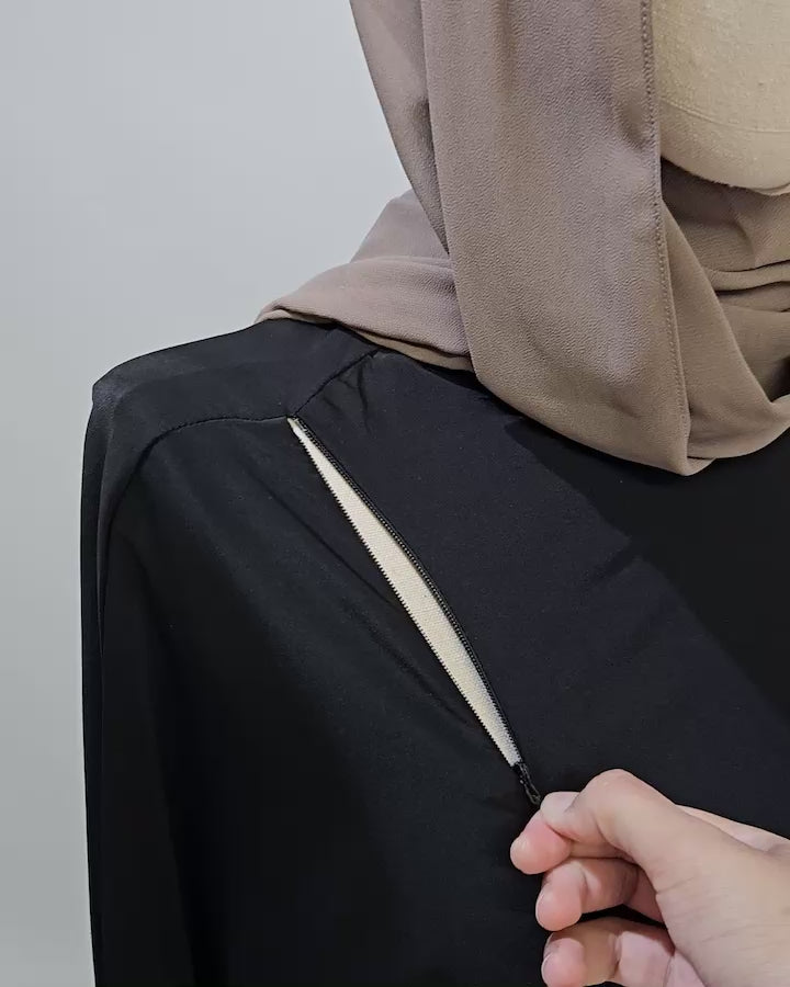 Close-up of the Fajr Noor nursing-friendly abaya in black showing the concealed zip breastfeeding access