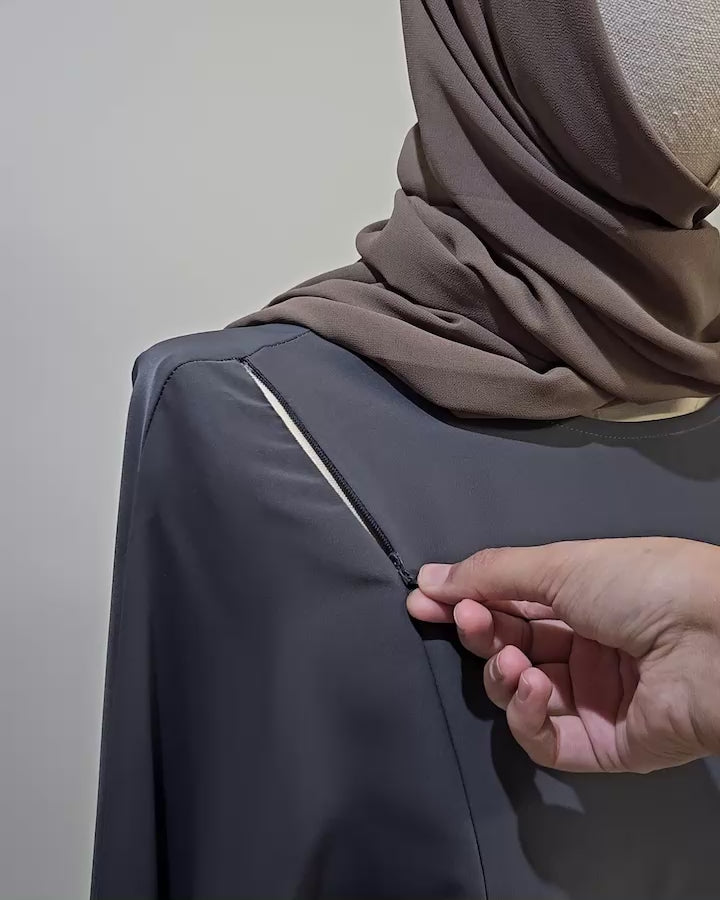 Close-up of the Fajr Noor nursing-friendly abaya in charcoal showing the concealed zip breastfeeding access