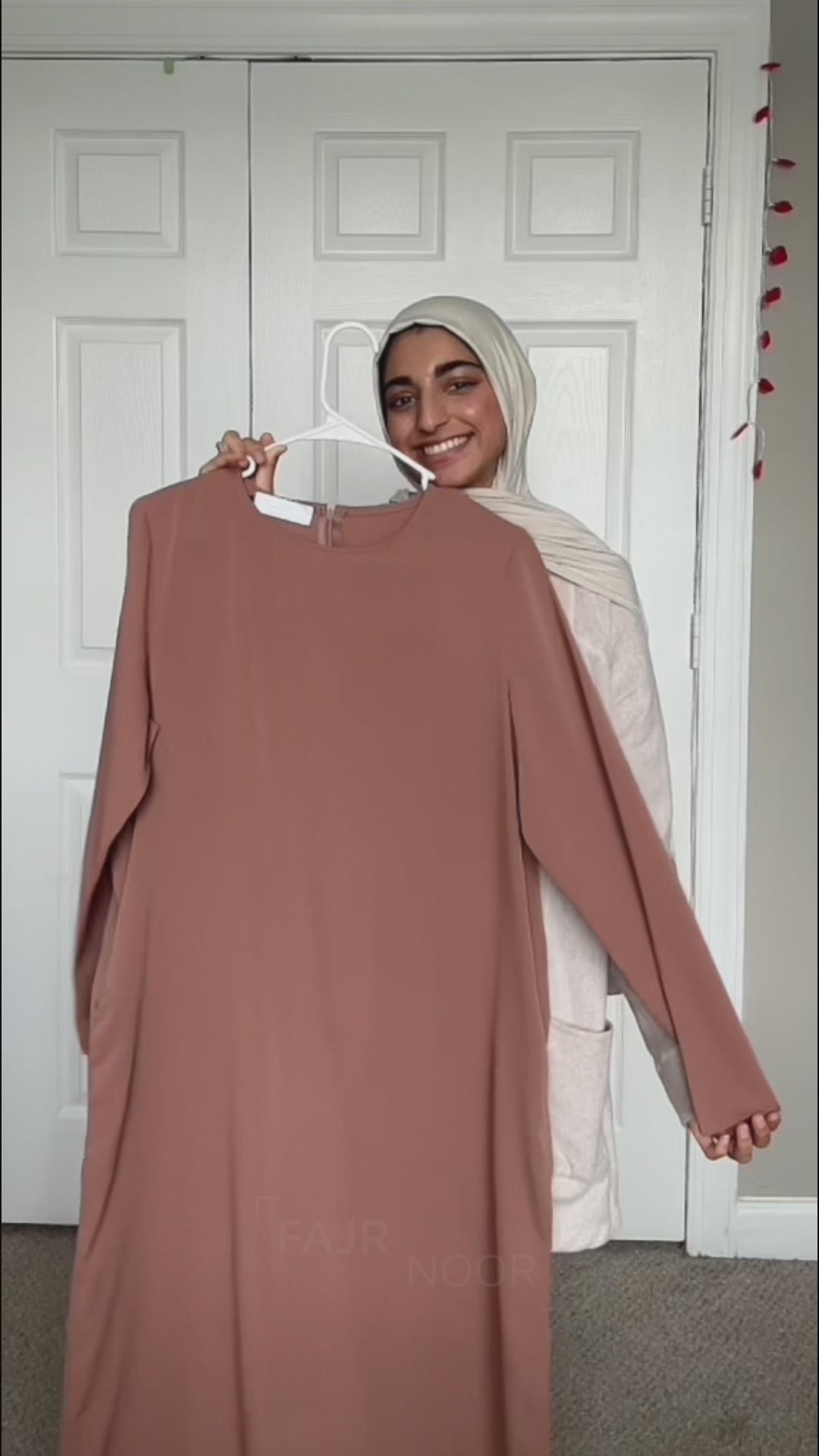 Woman wearing the Fajr Noor Khatijah Abaya in brown with a printed headscarf, showing a gold pendant necklace