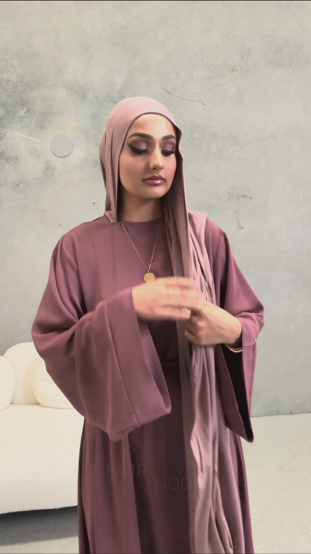 Woman wearing the Fajr Noor Khatijah Abaya in berry with a matching hijab in a studio setting