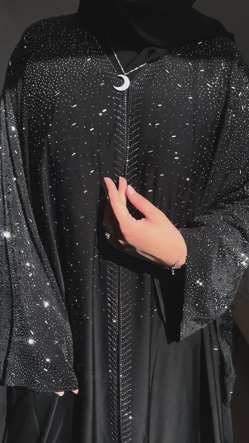 Woman showcasing the Fajr Noor Amina Abaya in black, Maryam Abaya in blue, and Nourah Abaya in coffee with jewelry