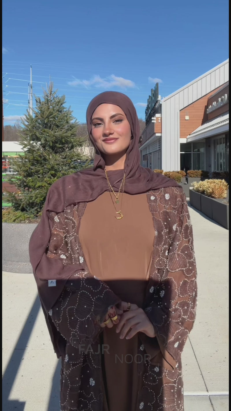 Woman outdoors wearing the Fajr Noor Sumayya Abaya in coffee brown with sheer floral embroidered overlay and matching hijab