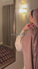 Woman wearing the Fajr Noor Aya Linen Abaya in mauve taupe, reflected in a mirror, a simple and elegant silhouette